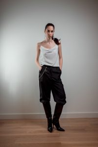 JAGYCH AW 25 ESSENTIALS BRUTAL REFINEMENT STRAP BLOUSE IN WHITE CRYSTAL CROSS EARINGS TROUSERS CHAIN